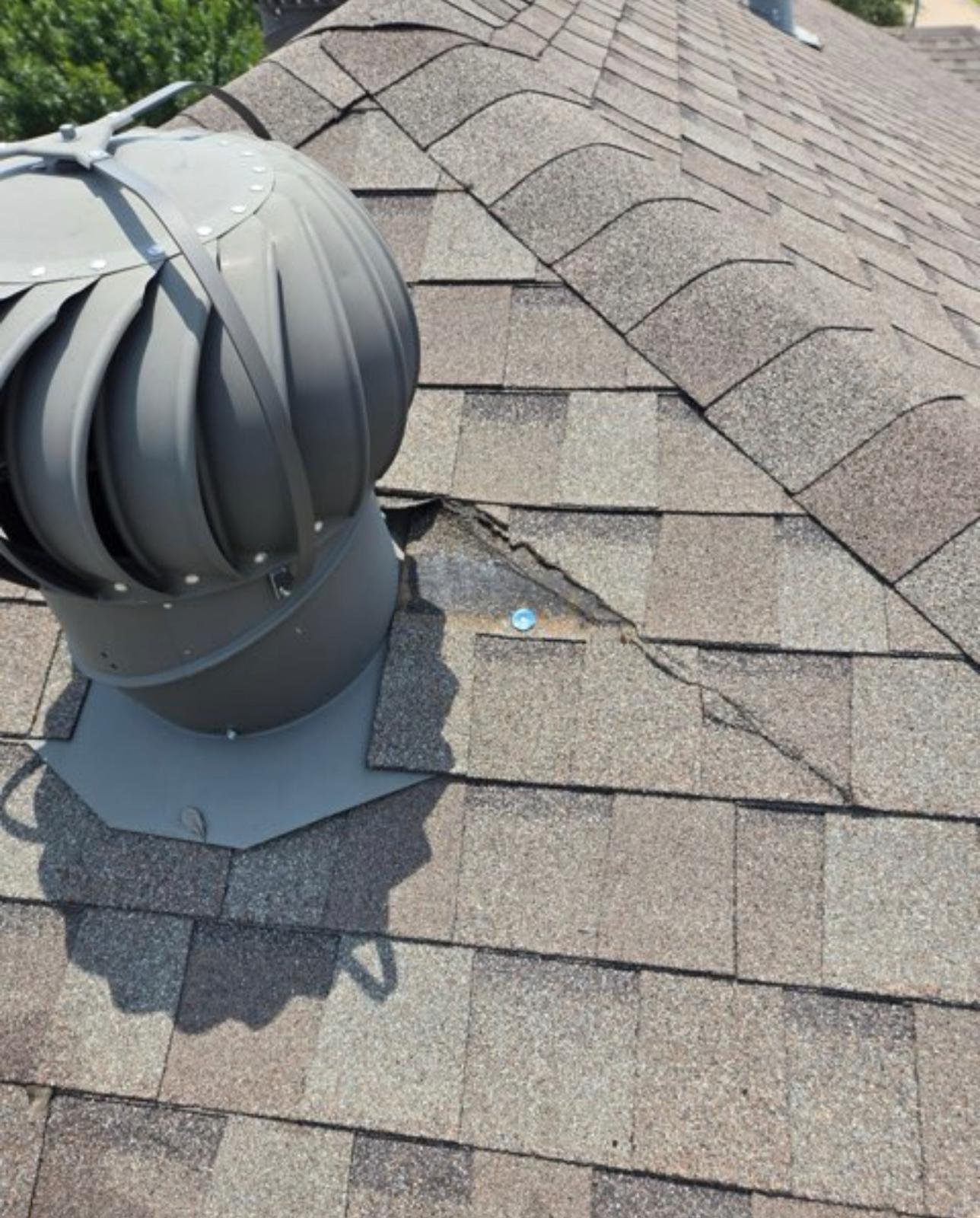 Hail damage — cracked shingles around roof vent