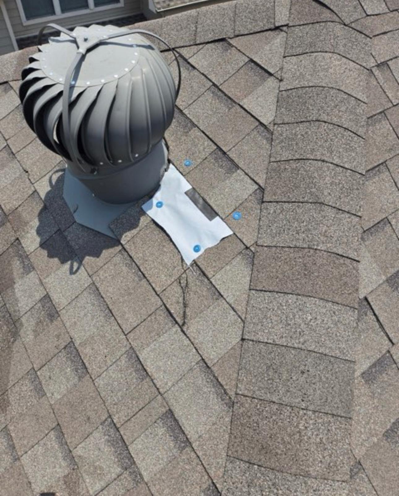 Storm damaged shingles with temporary patch